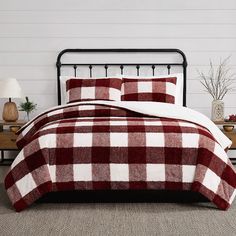 a red and white checkered comforter set on a bed in a room with two nightstands