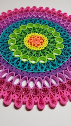 a multicolored paper doily with scissors on the bottom and one in the middle