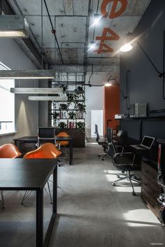 an office with orange chairs and black desks