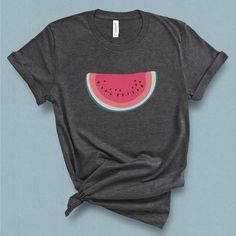 This minimal watermelon graphic t-shirt with its subtle retro feel comes straight from the pages of yesteryear. This wedge of watermelon graphic tee is supper sweet without being sticky. Its a perfect companion for your a pair of jean shorts and a hot summer day. DETAILS This Beautiful graphic t-shirt is made of 49% to 100% combed and ring-spun cotton and is very soft and comfortable to wear. Check the size card for specific fabrications per color. We use DTG technology and eco friendly inks all Cute Graphic Design Tops For Summer, Pink Graphic Design Shirt For Summer, Cute Summer Graphic T-shirt, Cute Summer T-shirt With Graphic Design, Pink Fruit Print T-shirt For Summer, Fun Summer Tops With Graphic Design, Watermelon Graphic Print T-shirt For Summer, Pink Fruit Print Graphic Tee, Watermelon Cotton Short Sleeve Top