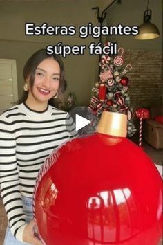 a woman standing next to a red christmas ornament