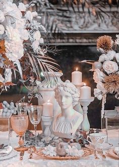 a table topped with white flowers and candles