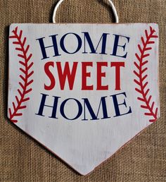 a wooden sign that says home sweet home with a baseball on it's side