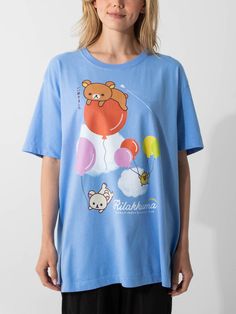 a woman wearing a blue t - shirt with an image of a teddy bear on it