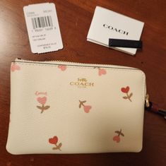 Adorable Coach Heaets And Fkowers Print Corner Zip Wristlet On Chalk Background With Burgundy Wrist Strap. Brand New, Never Used And Rare. Looks Gorgeous With The Red Coach Purse For Sale In My Closet. 6 1/4" X 4". Gold Tone Coach Emblem And Hardware. Smoke Free Home. No Returns Please. Coach Wallets As Spring Gifts, Cream Pouch Wristlet Gift, Cream Pouch Wristlet For Gift, Cream Pouch Wristlet As Gift, White Wallets For Spring Gift, Chalk Background, Hearts And Flowers, Black Wristlet, Leather Card Case