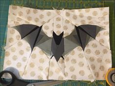 the paper is cut out to look like two bats, one black and one white