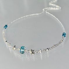 Genuine, premium-quality london blue topaz gemstone necklace, hand-crafted in sterling silver This stunning and detailed necklace is designed with a genuine, premium-quality, rondelle-shaped, teal-coloured london blue topaz gemstone.  The 6 - 6.5 mm stone is centered in a row of contrasting-shaped elements: Karen Hill silver stick beads clusters, sterling silver bicone and round beads; followed by tiny twin faceted london blue topaz beads.  This finely-faceted gemstone is crystal-clear with amazing clarity and sparkle.  This necklace is finished with a lobster claw clasp accented with two tiny topaz beads on each side. Elegant and minimal, this necklace is perfect by itself or layered with others. Please note this necklace is enlarged to show details.  Details: necklace length:  please cho London Blue Topaz Necklace, December Birthstone Necklace, Birthday Necklace Gift, Detailed Necklace, Blue Topaz Necklace, Topaz Necklace, Amethyst Necklace, Green Amethyst, London Blue Topaz