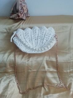 White Crochet Bag  Perfect Gift for her Gift for a woman's gift Girl bag This white knitted crochet bag is suitable for any occasion to dress up wedding outfit, for a night out on the town. It comes with gold metal detachable chain handle Handmade from 100% polyester cord Material: Gold metal shoulder strap  Zip Close  Metal magnetic clasps Satin lining with pockets.  Size:  Width 11"            Length 7"            Depth 2" Take a look at other   bags listed White Knitted Rectangular Shoulder Bag, White Knitted Shoulder Bag For Beach, White Hand Knitted Rectangular Shoulder Bag, White Hand-knitted Rectangular Shoulder Bag, White Knitted Beach Shoulder Bag, Hand Knitted White Rectangular Shoulder Bag, White Hand Knitted Shoulder Bag, White Crochet Pouch Bag Gift, White Crochet Pouch Bag As Gift