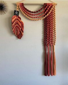 an orange and red wall hanging next to a white wall