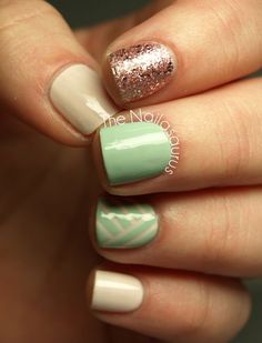 a woman's hand with some green and white nail polishes on her nails