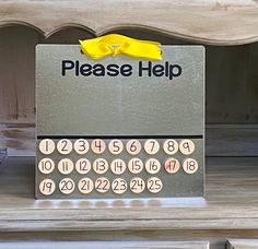 an old fashioned typewriter with yellow ribbon on it's display stand in front of a white dresser