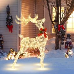 a lighted reindeer in front of a house