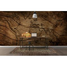 a desk with a laptop on it in front of a large rock wallpaper mural