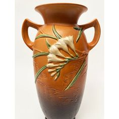 an orange vase with white flowers on it