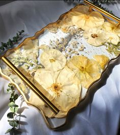 a tray with flowers on it sitting on a bed