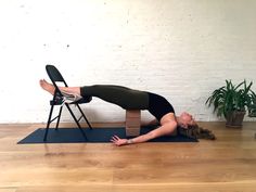 a woman is doing yoga on a chair