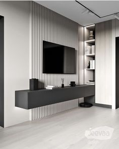 a modern living room with white walls and black entertainment center on the wall, built in bookshelves