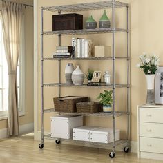 a shelving unit in a living room with white drawers and baskets on the bottom shelf