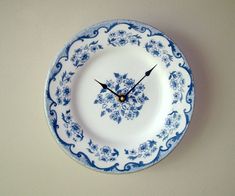 a blue and white plate with a clock on the wall in the middle of it