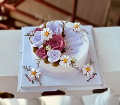 a white cake with pink and purple flowers on it