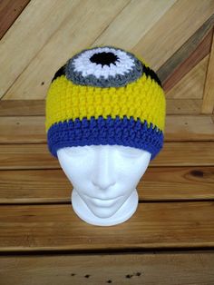 a crocheted hat with an evil eye on the front and bottom, sitting on a mannequin's head