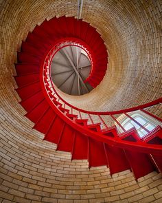 a red spiral staircase in a brick building