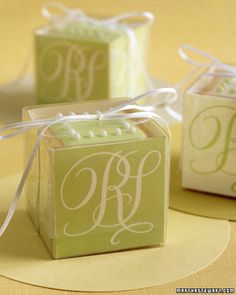 three small boxes with the letter b on them are tied up and ready to be used as favors