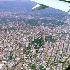 an airplane wing flying over a large city