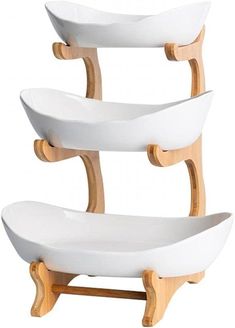 three white bowls are stacked on top of each other in the shape of a boat