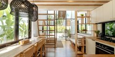 an open kitchen and dining area with wood flooring, white walls and ceiling beams