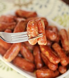 a fork with some kind of food in it on top of a bowl filled with peanuts