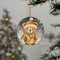 a glass ornament with a teddy bear on it hanging from a christmas tree