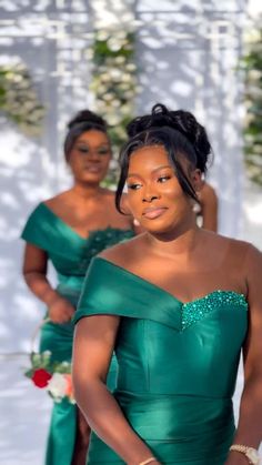 two women in green dresses standing next to each other