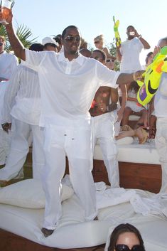 a man standing on top of a bed holding a yellow frisbee in his hand