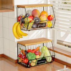 two metal baskets filled with fruits and vegetables on top of a counter next to a window