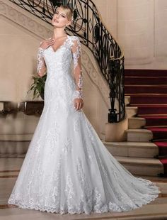 a woman in a wedding dress standing on the stairs