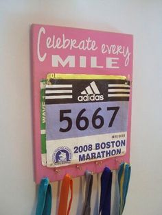 a marathon sign hanging on the side of a wall with ribbons attached to it's sides