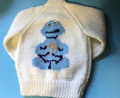 Super cute hand knit Cookie Monster sweater White and blue Giggly eggs on both front and back. Light weight(not wool) 2 1/2" ribbed waist and sleeves Waist is 16"around Arm length from collar to edge of ribbing 14" Top collar to bottom is 14" Probably fit 2-4 year old In excellent preloved condition Playful Blue Knitted Sweater, Cozy Handmade White Sweater, Cute Hand Knitted Blue Sweater, Cute Blue Hand-knitted Sweater, Cute Blue Hand Knitted Sweater, Handmade White Knit Sweater, Cute White Handmade Sweater, Cute Handmade White Sweater, Cute Hand Knitted White Sweater