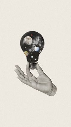 a hand holding an electric light bulb with planets on it