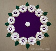 a purple and white flower design with green leaves on the top is made out of felt