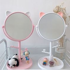 a pink vanity mirror sitting on top of a white shelf next to a toy panda bear