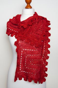 a red knitted shawl on a mannequin