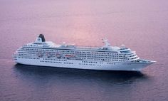 a cruise ship sailing in the ocean at sunset