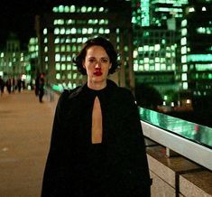 a woman standing in front of a cityscape at night