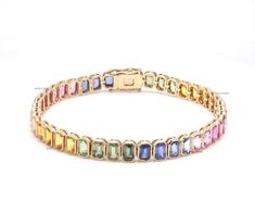 Rainbow sapphire emerald cut bezel tennis bracelet  gold | Natural multi sapphire bracelet gold | Vibrant rainbow sapphire bracelet gold GEMSTONE DETAILS : ✦ Gemstone : Rainbow Sapphire ✦ Gemstone Type : Natural ✦ Gemstone Size : 5x3 MM ✦ Gemstone Shape : Emerald Cut | Octagon Cut ✦ Gemstone Weight : 17.220 carats ✦ Gemstone Grade : AAA METAL DETAILS : ✦ Metal : 14K/18K Gold ✦ Metal Color : Yellow / White / Rose Gold ✦ Setting : Prong Setting ✦ Ring Box : Yes SHIPPING DETAILS : ✦ Shipped via : U Multi Sapphire Bracelets, Fine Jewelry With Multicolor Emerald Cut, Formal Rainbow Gemstone Jewelry, Rainbow Baguette Cut Jewelry Gift, Tennis Bracelet Gold, Rainbow Sapphires, Multi Sapphire, Rainbow Bracelet, Sapphire Bracelet