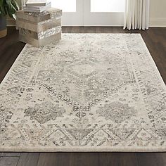 a white rug with an ornate design on the floor in front of a door and window