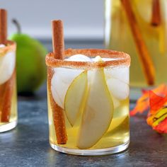 an apple cider cocktail with cinnamon and pear sangria in it on a table