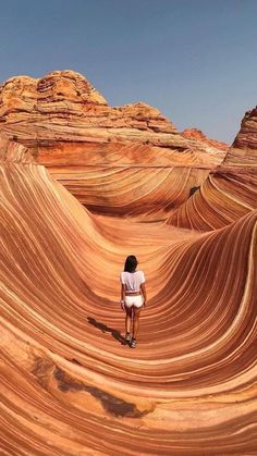 a person standing in the middle of an area that looks like wavy rocks and sand