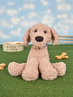 a stuffed dog sitting on the ground with his paws in front of him and some treats nearby