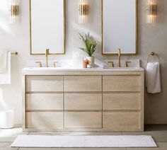 a bathroom with two sinks and mirrors on the wall